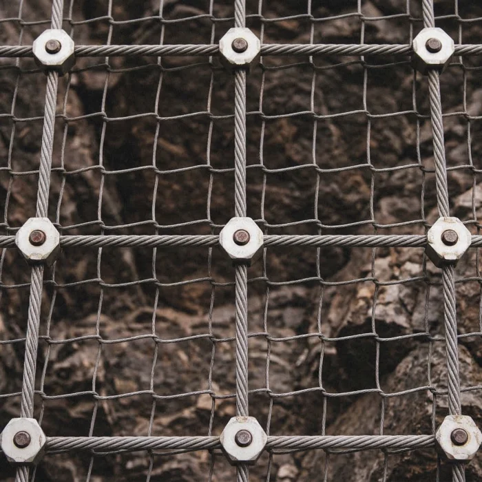 Close-up of rockfall netting and barrier system used for slope stabilization and rockfall protection