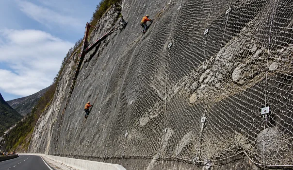 Active slope stabilization system using engineered solutions to reinforce unstable rock and soil slopes.